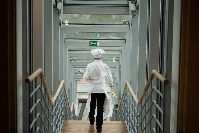 A baker in traditional clothing is seen walking down some stairs for an article on Cocoa and Cholate for Houghton & Mackay Magazine
