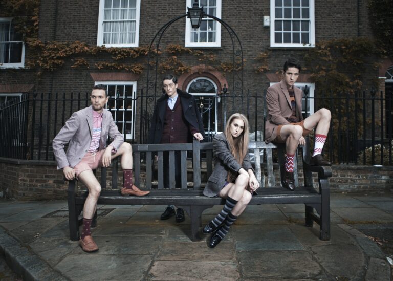 A group of models sits on a bench for a photo shoot by Doodoosonic, on an article by Hannah Burns for Houghton & Mackay, December 2023