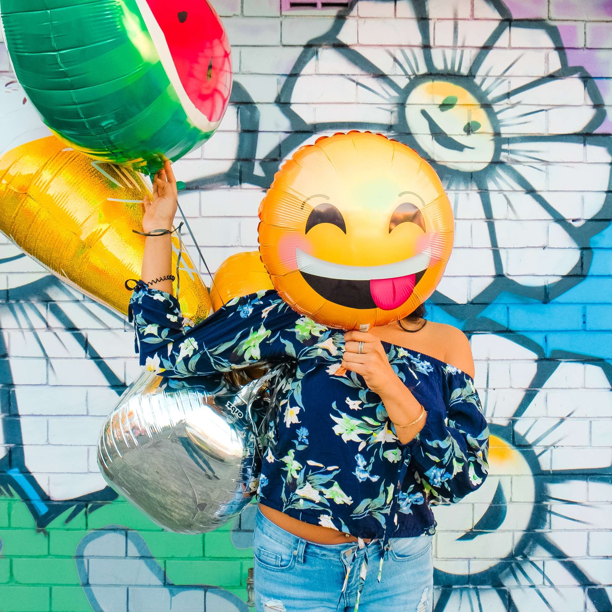 Photo of girl with balloons, with a smiling balloon infront of her face