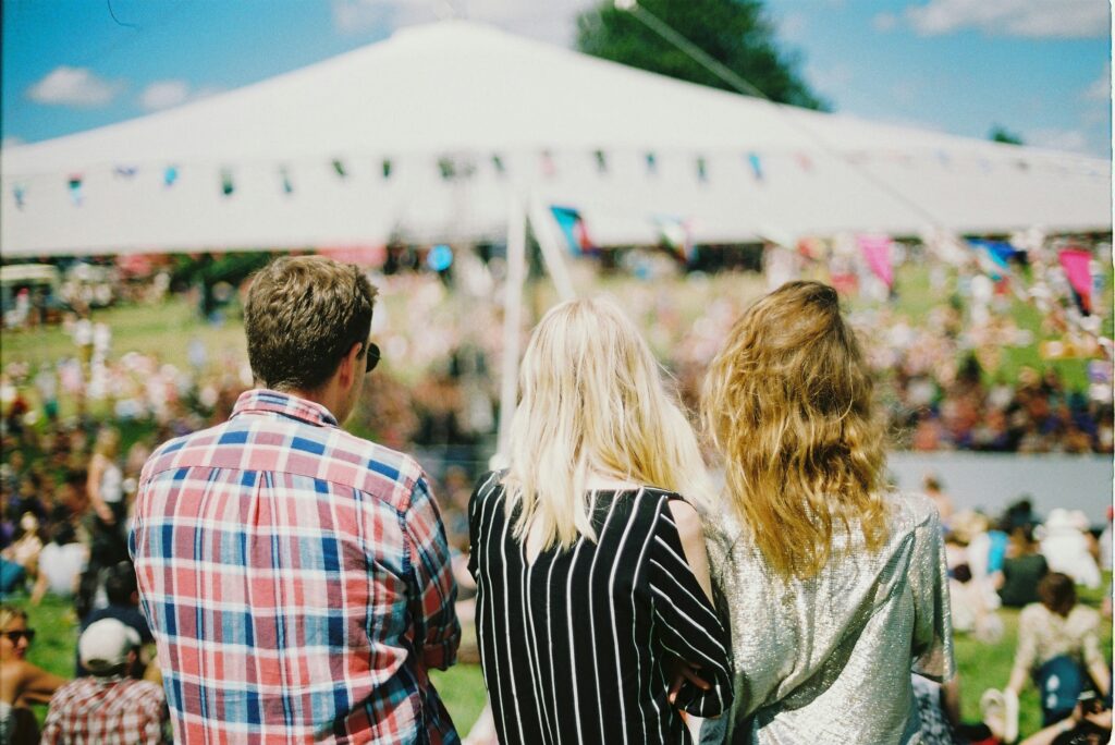 Three people sit together at a festival